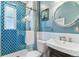 Bright bathroom features a beautifully tiled shower, toilet, sink with nice vanity and round mirror at 2614 E 13Th Ave, Denver, CO 80206