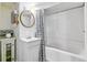 Well-lit bathroom features a shower with tub, patterned shower curtain, and white vanity at 2614 E 13Th Ave, Denver, CO 80206