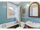 Charming bathroom with a window over the bathtub, and a pedestal sink with a vintage style mirror at 2614 E 13Th Ave, Denver, CO 80206