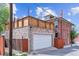 Rear garage with stone facade, white door, wooden accents and fenced area at 2614 E 13Th Ave, Denver, CO 80206