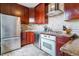 Well-equipped kitchen with stainless steel appliances, cherry cabinets, and tiled backsplash at 2614 E 13Th Ave, Denver, CO 80206