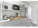 Cozy kitchenette features open shelving, wooden countertop, microwave and kitchen essentials at 2614 E 13Th Ave, Denver, CO 80206