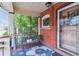 Inviting front porch with brick detail, seating, and colorful rug, perfect for relaxing outdoors at 2614 E 13Th Ave, Denver, CO 80206