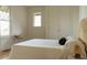 Calm bedroom with a woven headboard, white bedding, a small chair, and natural light from diamond-shaped windows at 3330 Bruce Randolph Ave, Denver, CO 80205