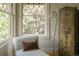 Bedroom featuring a chaise lounge, hardwood floors, windows with diamond-shaped grids, and a stylish vintage floor lamp at 3330 Bruce Randolph Ave, Denver, CO 80205