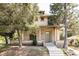 Charming brick two-story home with covered front porch and mature trees providing shade at 3330 Bruce Randolph Ave, Denver, CO 80205