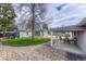 Expansive backyard features a covered patio, turf, rock landscaping, sheds, and mature trees at 5477 E Asbury Ave, Denver, CO 80222