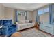 Bright bedroom with a sofa and a blue armchair next to a guitar and keyboard at 5477 E Asbury Ave, Denver, CO 80222