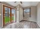 Bright bedroom featuring wood-look flooring, neutral walls, double doors to yard, plus a window for natural light at 5477 E Asbury Ave, Denver, CO 80222