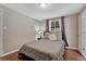 Cozy bedroom features a large bed, wood floors, and a window with purple curtains at 5477 E Asbury Ave, Denver, CO 80222