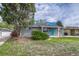 Charming home exterior features a landscaped yard, gray brick, and an eye-catching blue door at 5477 E Asbury Ave, Denver, CO 80222