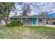 Charming home exterior features a landscaped yard, gray brick, and an eye-catching blue door at 5477 E Asbury Ave, Denver, CO 80222