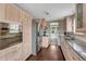 Modern kitchen with stainless steel appliances, granite countertops, and light wood cabinets and dark hardwood floors at 5477 E Asbury Ave, Denver, CO 80222