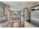 Bright kitchen with stainless steel appliances, wood floors, granite counters, and adjacent dining area at 5477 E Asbury Ave, Denver, CO 80222