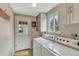 Functional laundry area features cabinetry, a window for natural light, and convenient washer and dryer hookups at 5477 E Asbury Ave, Denver, CO 80222