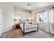 Bright bedroom featuring neutral decor, a large window, and a decorative wrought iron bed frame at 19431 E Hamilton Pl, Aurora, CO 80013