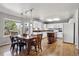 Well-lit kitchen with white cabinets, stainless appliances, island seating, and a dining area at 19431 E Hamilton Pl, Aurora, CO 80013