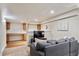 Finished basement rec room with a large sofa, built-in desk and TV at 19431 E Hamilton Pl, Aurora, CO 80013