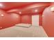 Finished basement with carpet, platform and storage, painted with red color at 2454 Ambience Ln, Castle Rock, CO 80109