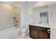 Well-lit bathroom featuring a shower over tub, single sink vanity and neutral tiling at 2454 Ambience Ln, Castle Rock, CO 80109