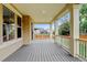Spacious covered patio with wood floors, support columns, and backyard views at 2454 Ambience Ln, Castle Rock, CO 80109