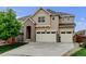 Beautiful two-story home showcasing a manicured lawn and a spacious three-car garage at 2454 Ambience Ln, Castle Rock, CO 80109