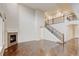 Bright living room features a fireplace, hardwood floors, and a staircase leading to the second floor balcony at 2454 Ambience Ln, Castle Rock, CO 80109