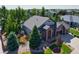 This aerial showcases the home's well-kept landscaping, brickwork, and the surrounding lush neighborhood at 7472 Iridium Way, Castle Rock, CO 80108