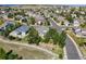 An aerial view shows a well-planned residential neighborhood with a mix of homes and green spaces under a blue sky at 7472 Iridium Way, Castle Rock, CO 80108