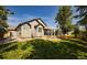 Expansive backyard with a covered patio, mature trees, and manicured lawn perfect for outdoor enjoyment at 7472 Iridium Way, Castle Rock, CO 80108