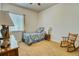 This bedroom has carpet floors, a window for natural light and rocking chair near a side table at 7472 Iridium Way, Castle Rock, CO 80108