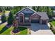 Charming brick home features manicured landscaping, a spacious driveway, and an attached two-car garage at 7472 Iridium Way, Castle Rock, CO 80108