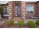 This home's front facade features brick accents, decorative windows, and a neat garden, highlighting its architectural details at 7472 Iridium Way, Castle Rock, CO 80108