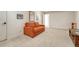 Comfortable living area with an orange loveseat and neutral carpet at 9316 E Harvard Ave, Denver, CO 80231