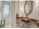 Stylish powder room with granite countertop, unique sink, and decorative mirror at 9316 E Harvard Ave, Denver, CO 80231