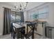 Dining area with chandelier, table with seating, adjacent to sliding glass door, and storage cabinet at 6705 S Field St # 801, Littleton, CO 80128