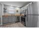 Modern kitchen with stainless steel appliances, gray cabinets, and bright natural light from the window at 6705 S Field St # 801, Littleton, CO 80128