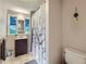 Bathroom boasts updated vanity, neutral tile flooring, and a shower with decorative curtain at 2626 N Steele St, Denver, CO 80205