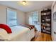 Comfortable bedroom with hardwood floors, natural light, and a bookshelf at 2626 N Steele St, Denver, CO 80205