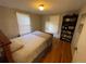 Cozy bedroom with hardwood floors, built-in bookshelf, and ample natural light at 2626 N Steele St, Denver, CO 80205