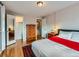 Cozy bedroom featuring wood floors, a dresser, and a closet with mirrored doors at 2626 N Steele St, Denver, CO 80205