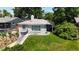 Charming single-story home featuring a stone chimney, lovely brickwork and lush green lawn at 2626 N Steele St, Denver, CO 80205