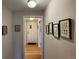 Inviting hallway with hardwood floors and decorative artwork leading to the front door at 2626 N Steele St, Denver, CO 80205