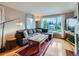 Bright living room featuring a comfortable couch, large window, and hardwood flooring at 2626 N Steele St, Denver, CO 80205