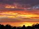 Dramatic sunset view featuring vibrant colors, mountains, and trees in silhouette at 2626 N Steele St, Denver, CO 80205