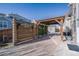 View of backyard with covered patio, privacy screen, and custom landscaping at 3482 E 143Rd Dr, Thornton, CO 80602