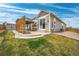 View of home backyard with covered patio, small grass yard, and rock landscaping at 3482 E 143Rd Dr, Thornton, CO 80602