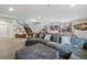 Open basement featuring a large sectional sofa, wet bar, and staircase at 3482 E 143Rd Dr, Thornton, CO 80602