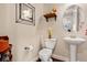 Charming powder room with pedestal sink, toilet, and decorative shelving at 3482 E 143Rd Dr, Thornton, CO 80602