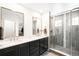Bathroom featuring a new frameless glass shower, black cabinets with double sinks and mirrors at 14454 Grape Way, Brighton, CO 80602